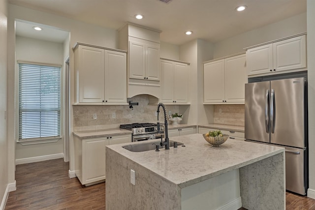 kitchen with a sink, baseboards, freestanding refrigerator, and backsplash