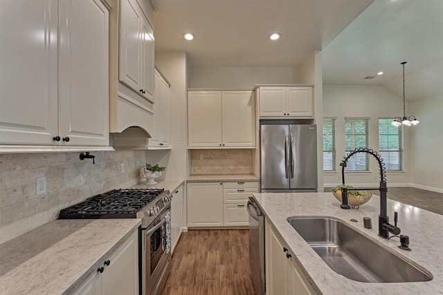 kitchen with dark wood-style flooring, light stone countertops, appliances with stainless steel finishes, and a sink