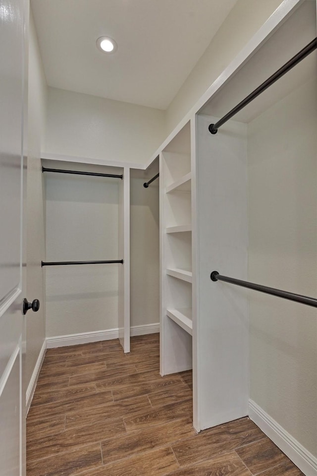 walk in closet with wood finished floors