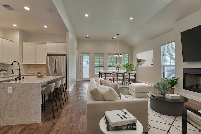 living room featuring baseboards, wood finished floors, and visible vents