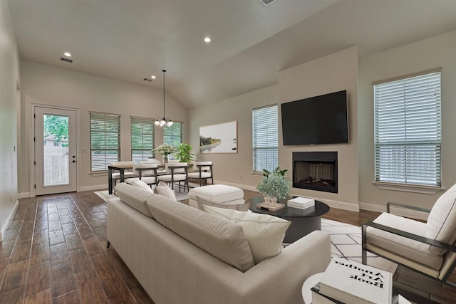 living room featuring baseboards, an inviting chandelier, plenty of natural light, and visible vents