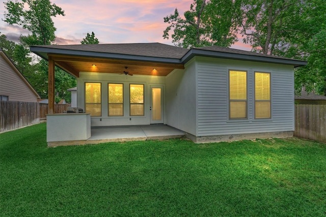 rear view of property featuring a fenced backyard, ceiling fan, a patio area, and a yard