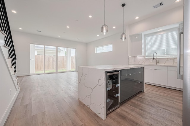 kitchen featuring a sink, visible vents, modern cabinets, and light wood finished floors