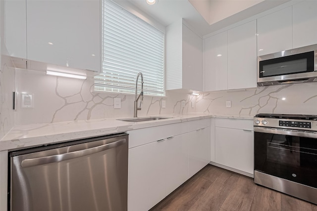 kitchen featuring a sink, modern cabinets, white cabinets, and stainless steel appliances
