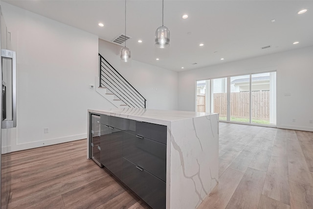 kitchen featuring visible vents, a kitchen island, modern cabinets, light wood-type flooring, and recessed lighting
