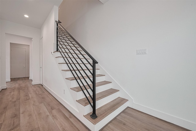 stairway with baseboards, recessed lighting, and wood finished floors