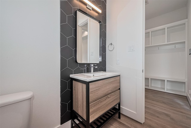 bathroom with vanity, baseboards, toilet, and wood finished floors