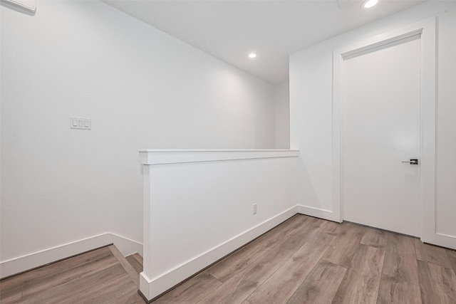 spare room with baseboards, recessed lighting, and wood finished floors