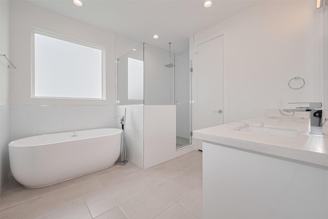 full bath with a freestanding tub, a shower stall, tile patterned floors, and vanity