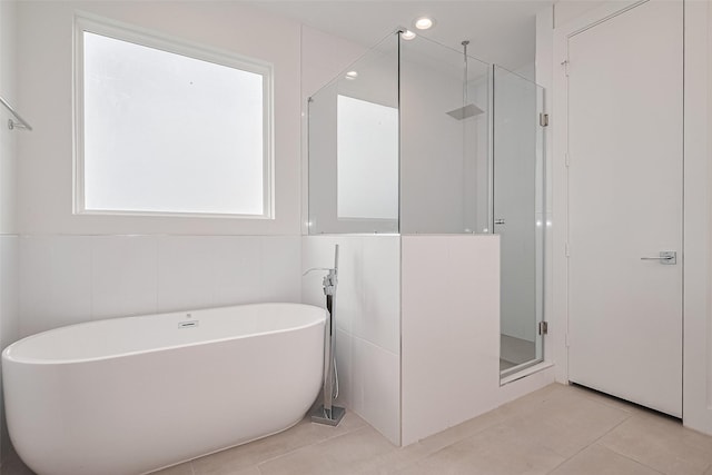 bathroom featuring tile patterned flooring, recessed lighting, a soaking tub, and a shower stall