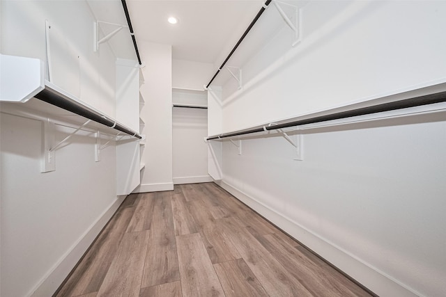 walk in closet with wood finished floors