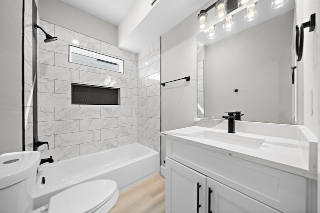 bathroom with toilet, wood finished floors, shower / bathing tub combination, and vanity