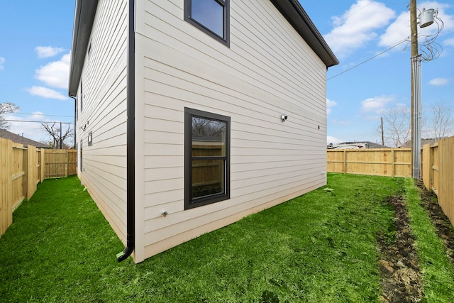 view of side of property featuring a fenced backyard and a yard