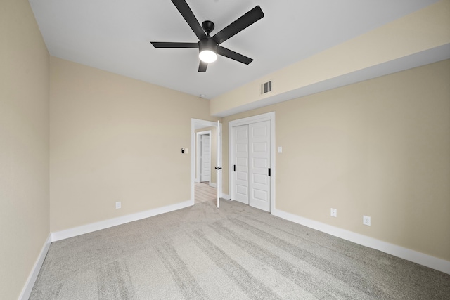 carpeted empty room featuring baseboards, a ceiling fan, and visible vents