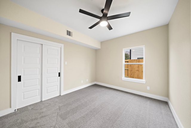 unfurnished bedroom featuring ceiling fan, carpet, baseboards, visible vents, and a closet
