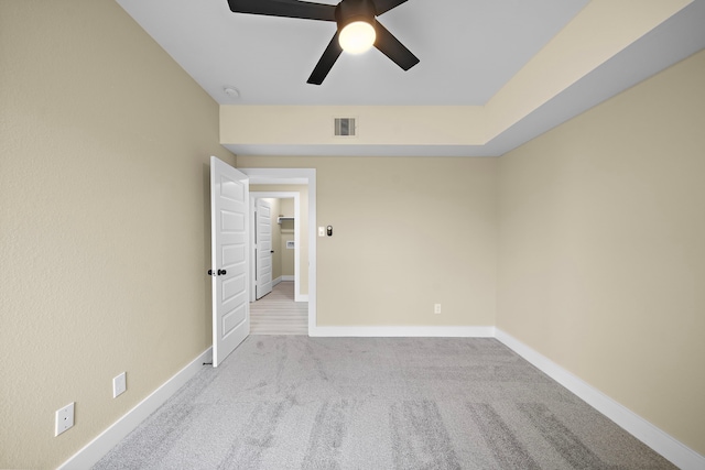 spare room with carpet floors, a ceiling fan, baseboards, and visible vents