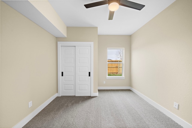 unfurnished bedroom featuring a ceiling fan, baseboards, carpet, and a closet