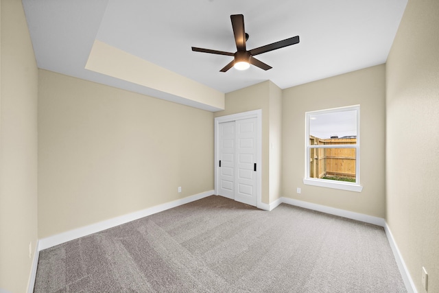 unfurnished bedroom with a ceiling fan, baseboards, carpet, and a closet