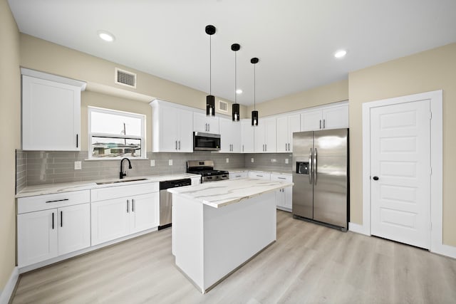 kitchen with visible vents, a sink, light wood-type flooring, and stainless steel appliances