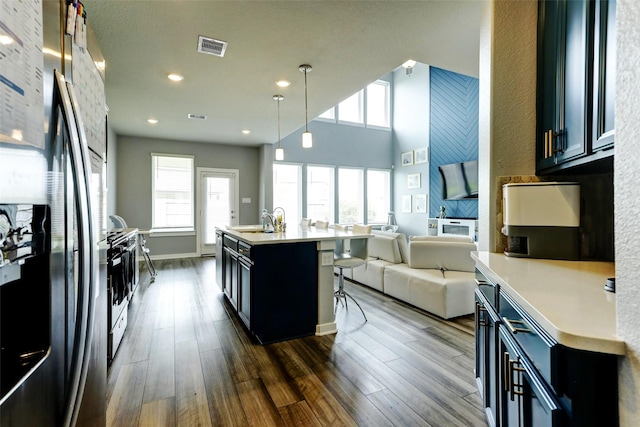 4910 Magnolia Springs Dr, Pearland, TX 77584 - kitchen featuring visible vents, freestanding refrigerator, open floor plan, dark cabinets, and a sink