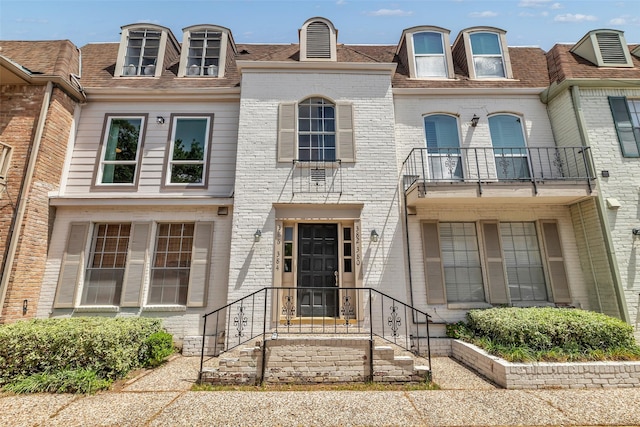 386 N Post Oak Ln, Houston, TX 77024 - townhome / multi-family property with a balcony, brick siding, and a shingled roof