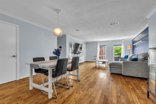 386 N Post Oak Ln, Houston, TX 77024 - dining space featuring a textured ceiling, crown molding, and wood finished floors