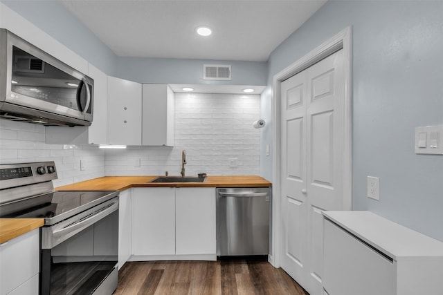 386 N Post Oak Ln, Houston, TX 77024 - kitchen with appliances with stainless steel finishes, butcher block counters, a sink, and white cabinets