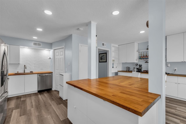 386 N Post Oak Ln, Houston, TX 77024 - kitchen with appliances with stainless steel finishes, wood counters, open shelves, a textured ceiling, and white cabinets