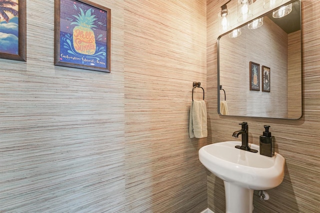 bathroom featuring a sink and tile walls