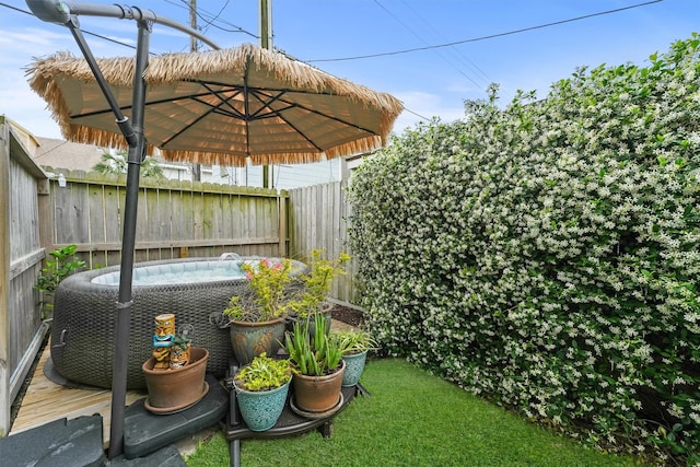 view of yard featuring a hot tub and fence