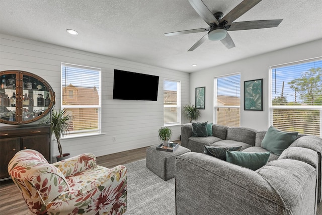 living area with recessed lighting, a textured ceiling, ceiling fan, and wood finished floors