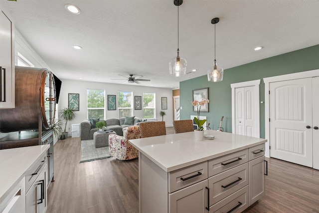 kitchen featuring recessed lighting, light countertops, dark wood-type flooring, and decorative light fixtures