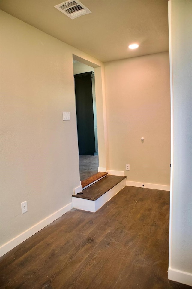 empty room with recessed lighting, baseboards, visible vents, and wood finished floors