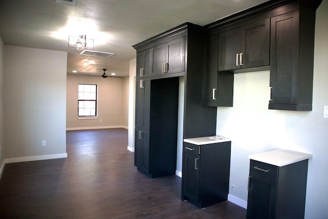 kitchen featuring light countertops, baseboards, dark wood-style flooring, and visible vents