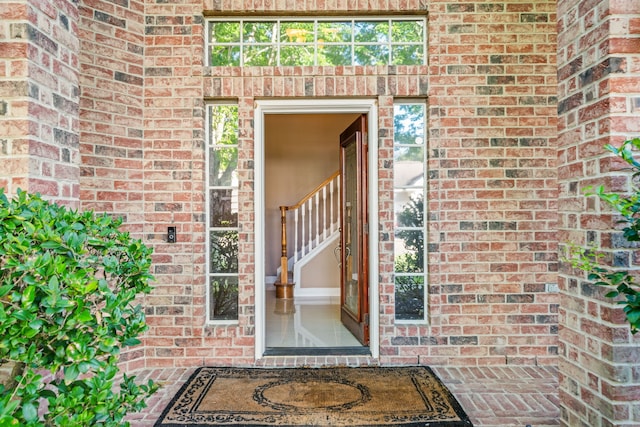 view of exterior entry with brick siding