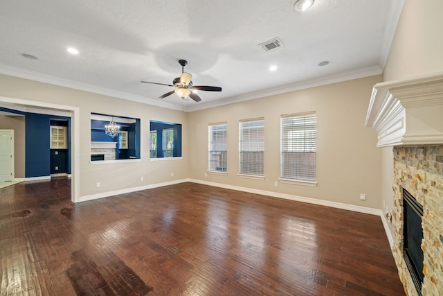 unfurnished living room with visible vents, a stone fireplace, a wealth of natural light, and ceiling fan with notable chandelier