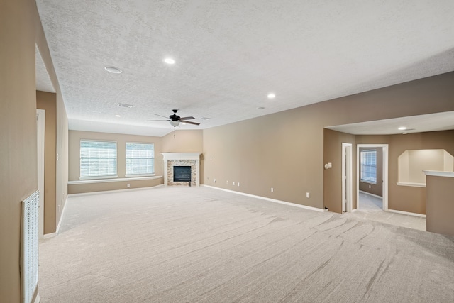 unfurnished living room with visible vents, light carpet, baseboards, ceiling fan, and a textured ceiling