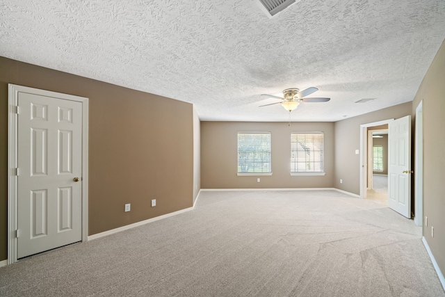 unfurnished room with a ceiling fan, baseboards, visible vents, and light carpet