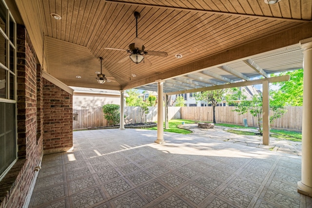 view of patio featuring a fenced backyard, a ceiling fan, and an outdoor fire pit