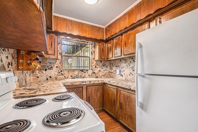 189 Lake Livingston Blvd, Livingston, TX 77351 - kitchen with decorative backsplash, crown molding, brown cabinets, light countertops, and white appliances