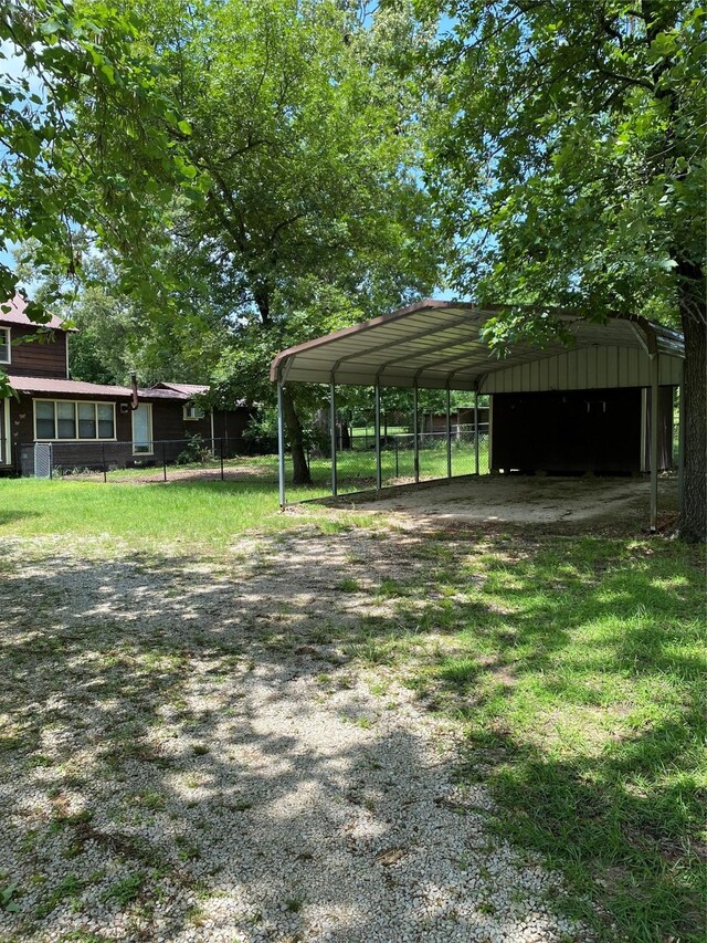 189 Lake Livingston Blvd, Livingston, TX 77351 - exterior space with fence, a detached carport, and gravel driveway