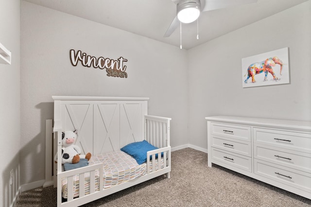 bedroom with baseboards, a ceiling fan, a nursery area, and light colored carpet