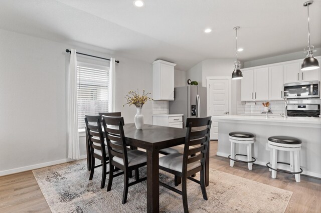 dining area featuring recessed lighting, baseboards, lofted ceiling, and light wood-style floors