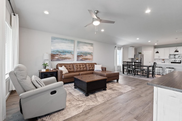 living room featuring recessed lighting, a ceiling fan, and light wood-style flooring