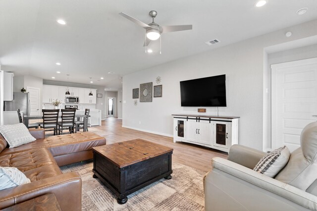 living room featuring a ceiling fan, baseboards, visible vents, and recessed lighting