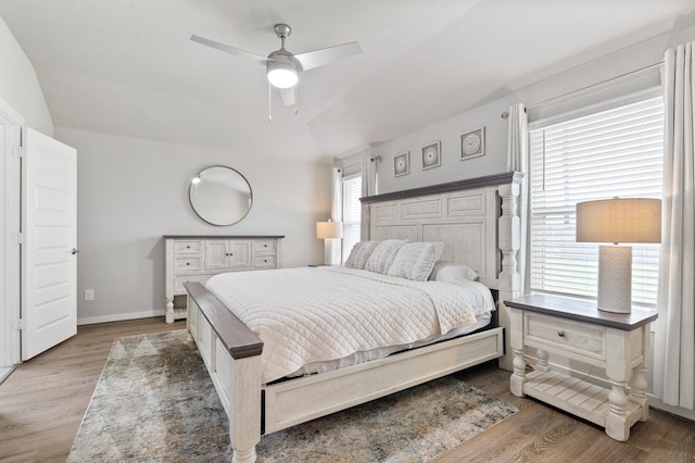 bedroom featuring baseboards, ceiling fan, wood finished floors, and vaulted ceiling