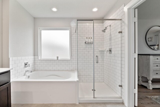 bathroom featuring vanity, recessed lighting, a garden tub, and a shower stall