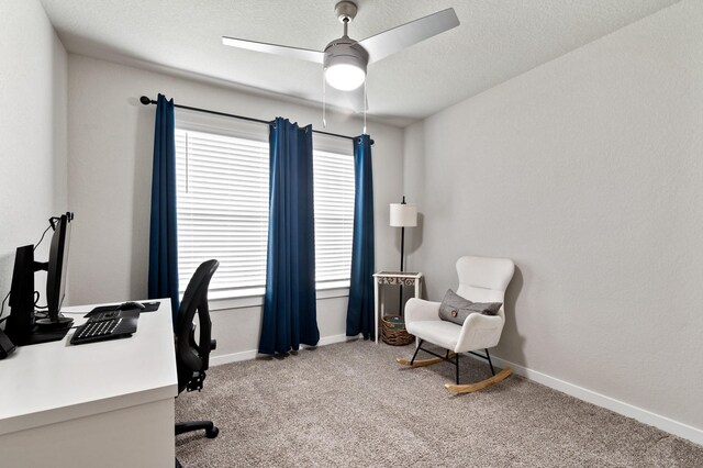 office featuring light colored carpet, a ceiling fan, and baseboards
