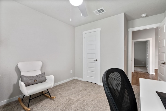 carpeted office with baseboards, ceiling fan, and visible vents
