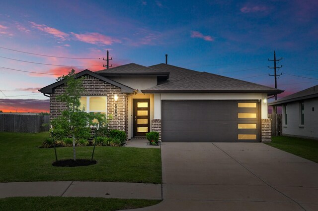view of front of property featuring fence, an attached garage, brick siding, concrete driveway, and a yard